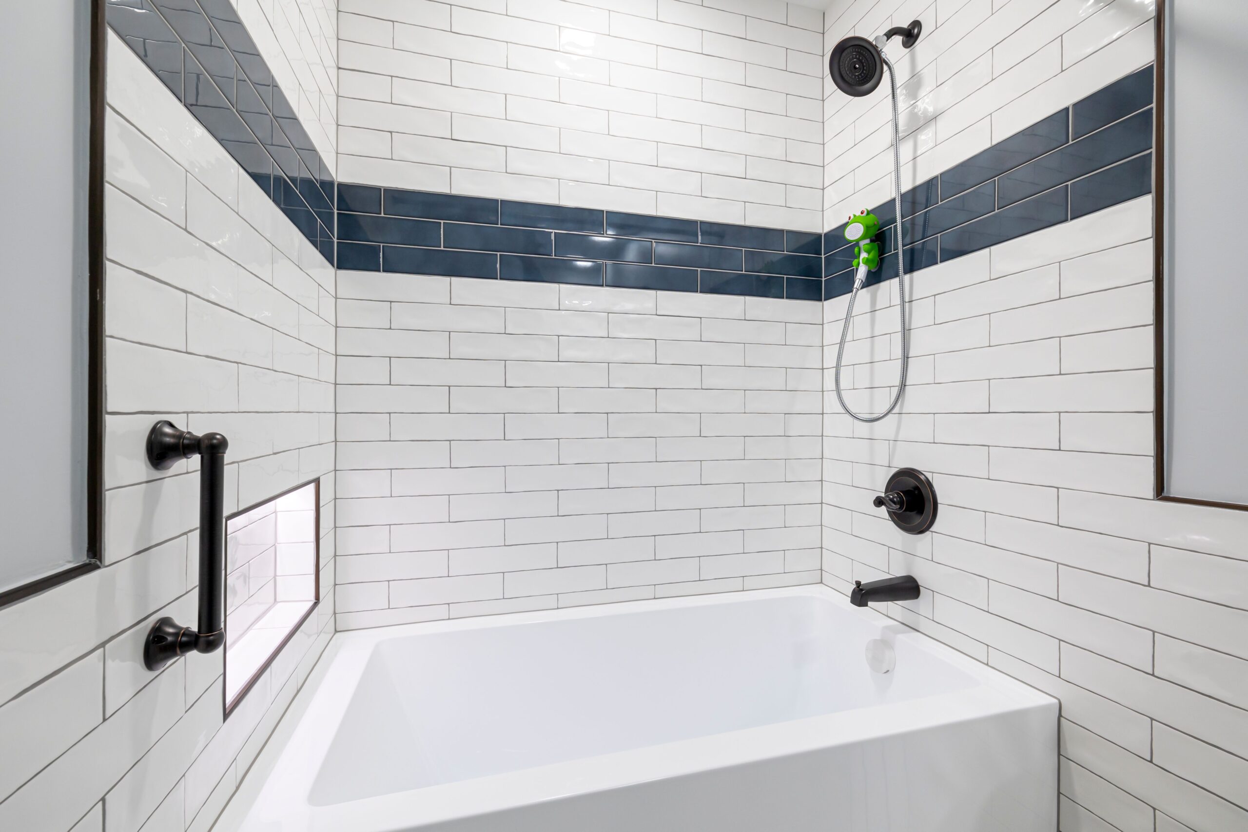 Sleek, minimalist bathroom with white and blue tiles and contemporary fixtures.